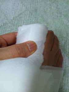 足の指先を覆う包帯の巻き方-指先が包帯の真ん中に来るように包帯を当てて折り返します。