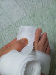 足の指先を覆う包帯の巻き方-指の付け根の前で折り返します。